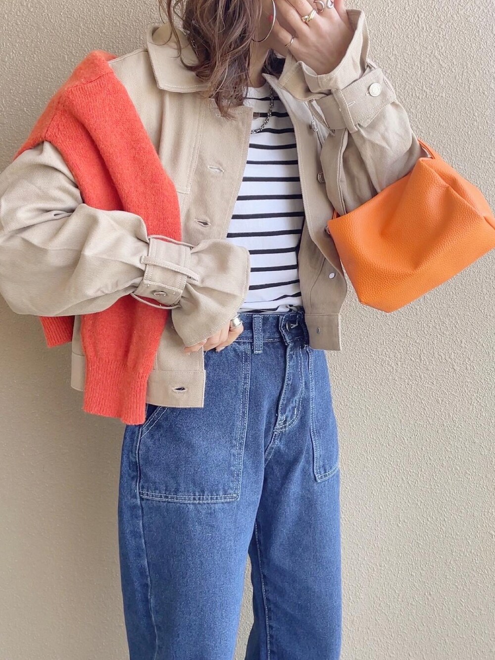 ベージュ系のデニムジャケット、ブルー系のデニムパンツ、オレンジ系のスニーカーを着用したレディースの春コーディネートの5枚目の写真