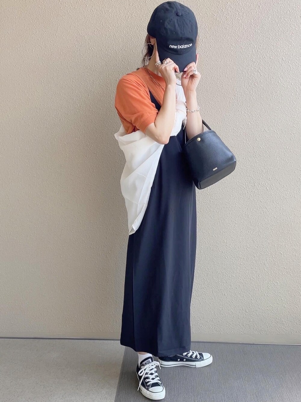 ホワイト系のシャツ/ブラウス、ブラック系のTシャツ/カットソー、ブルー系のデニムパンツを着用したレディースの春コーディネートの2枚目の写真