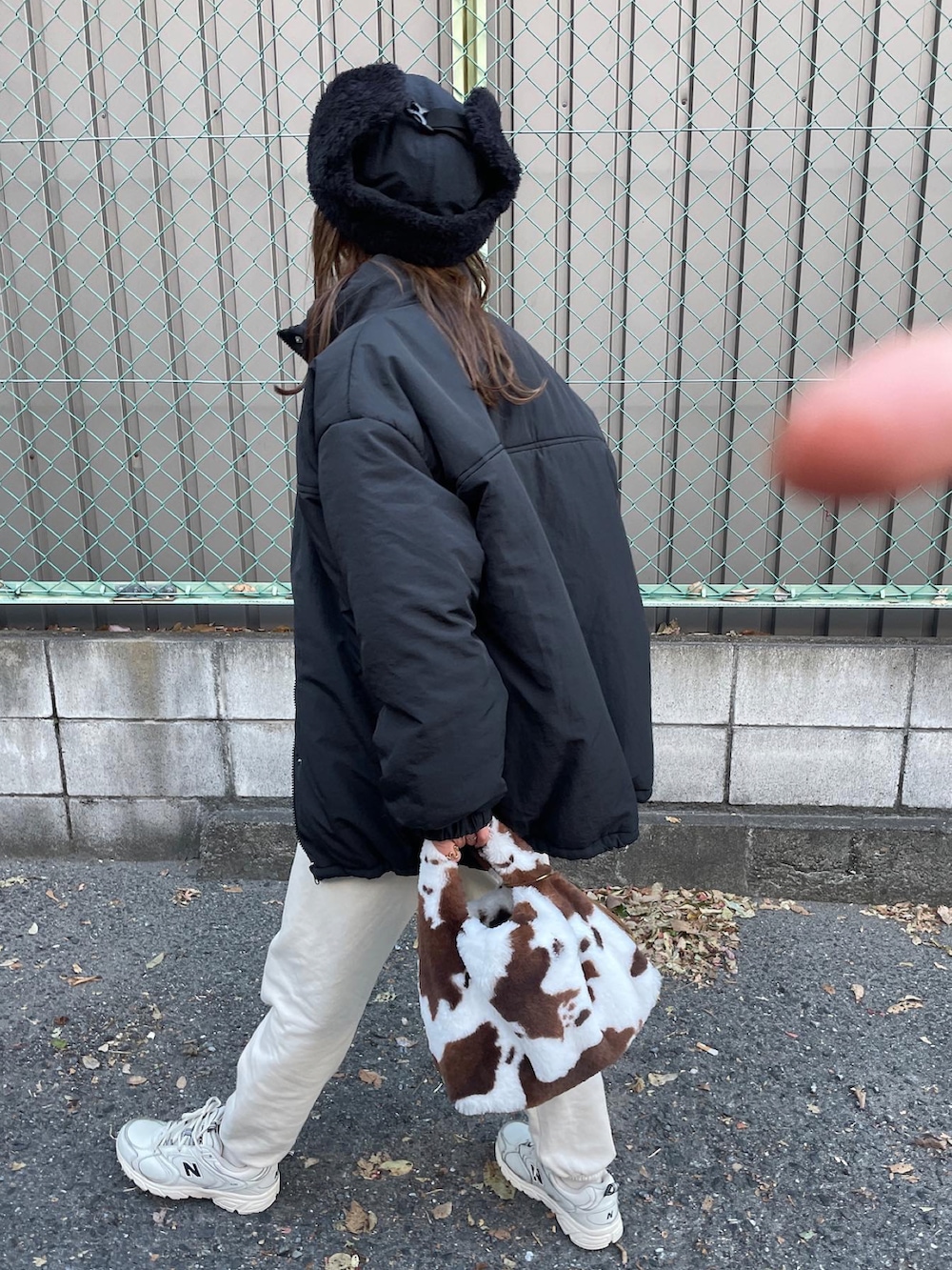 グレー系のスウェット、ブラック系のダウンジャケット/コート、ブラック系のハットを着用したレディースの冬コーディネートの4枚目の写真