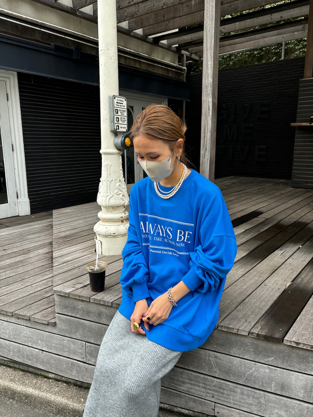 ブルー系のスウェット、グレー系のスカート、グレー系のスニーカーを着用したレディースの秋コーディネートの4枚目の写真