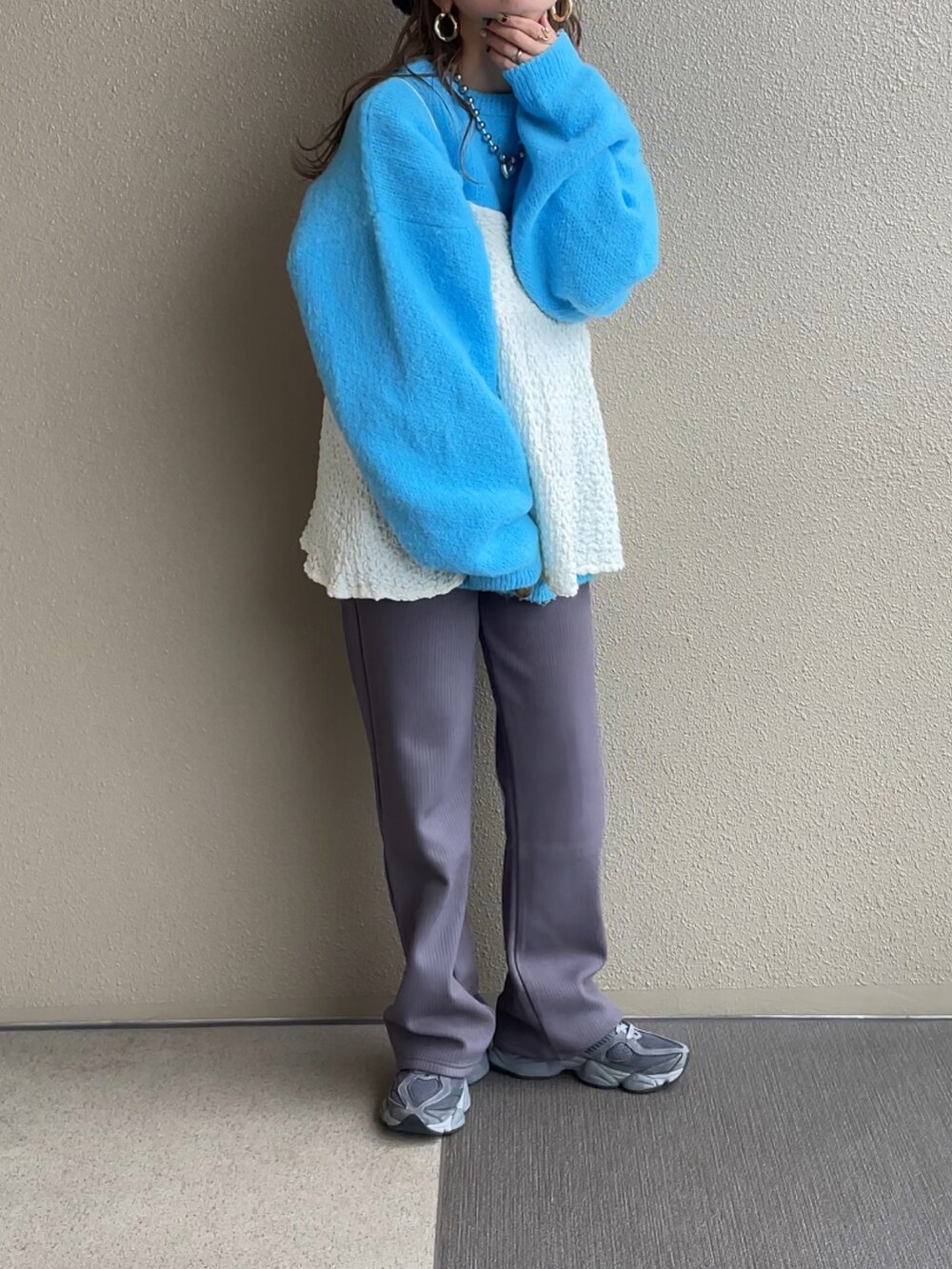 ブルー系のニット/セーター、ホワイト系のシャツ/ブラウス、グレー系のその他パンツを着用したレディースの秋コーディネートの3枚目の写真