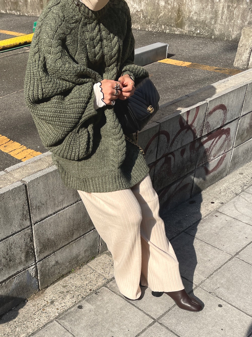 グリーン系のニット/セーター、ベージュ系のその他パンツ、ブラウン系のブーツを着用したレディースの秋コーディネートの2枚目の写真