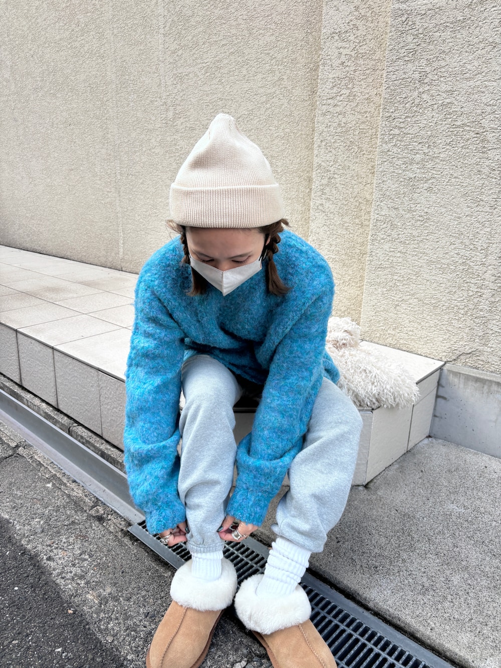 ブルー系のニット/セーター、ホワイト系のバッグ、ベージュ系のその他シューズを着用したレディースの冬コーディネートの2枚目の写真