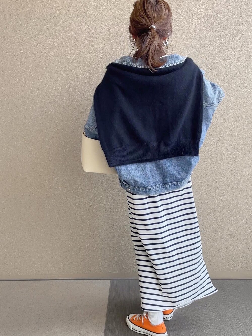 ホワイト系のワンピース/ドレス、ブルー系のデニムジャケット、オレンジ系のスニーカーを着用したレディースの冬コーディネートの2枚目の写真