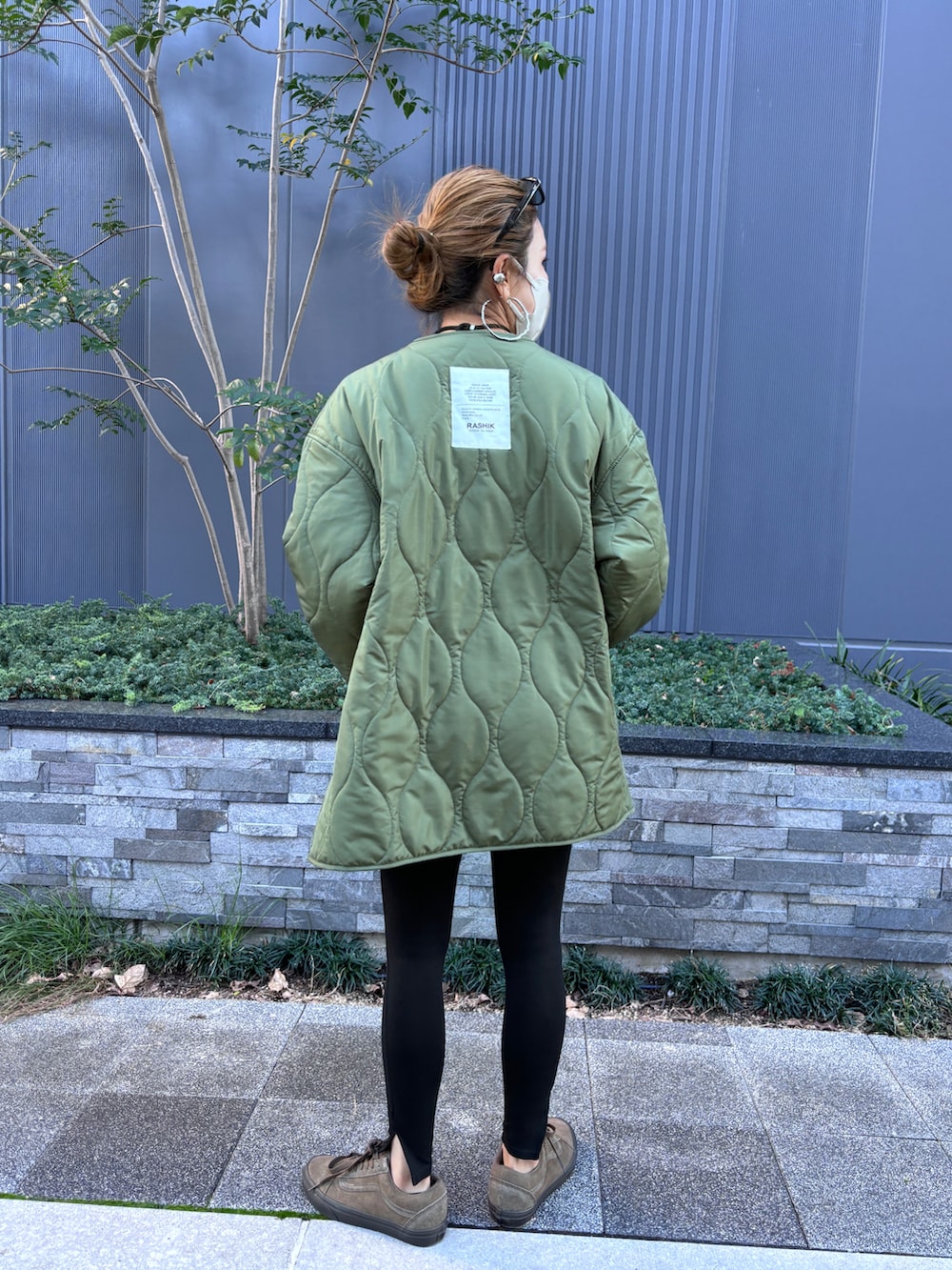 グレー系のTシャツ/カットソー、ブラウン系のトートバッグ、グリーン系のモッズコートを着用したレディースの秋コーディネートの4枚目の写真