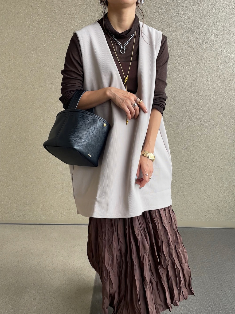 ベージュ系のベスト、ブラック系のその他パンツを着用したレディースの秋コーディネートの3枚目の写真