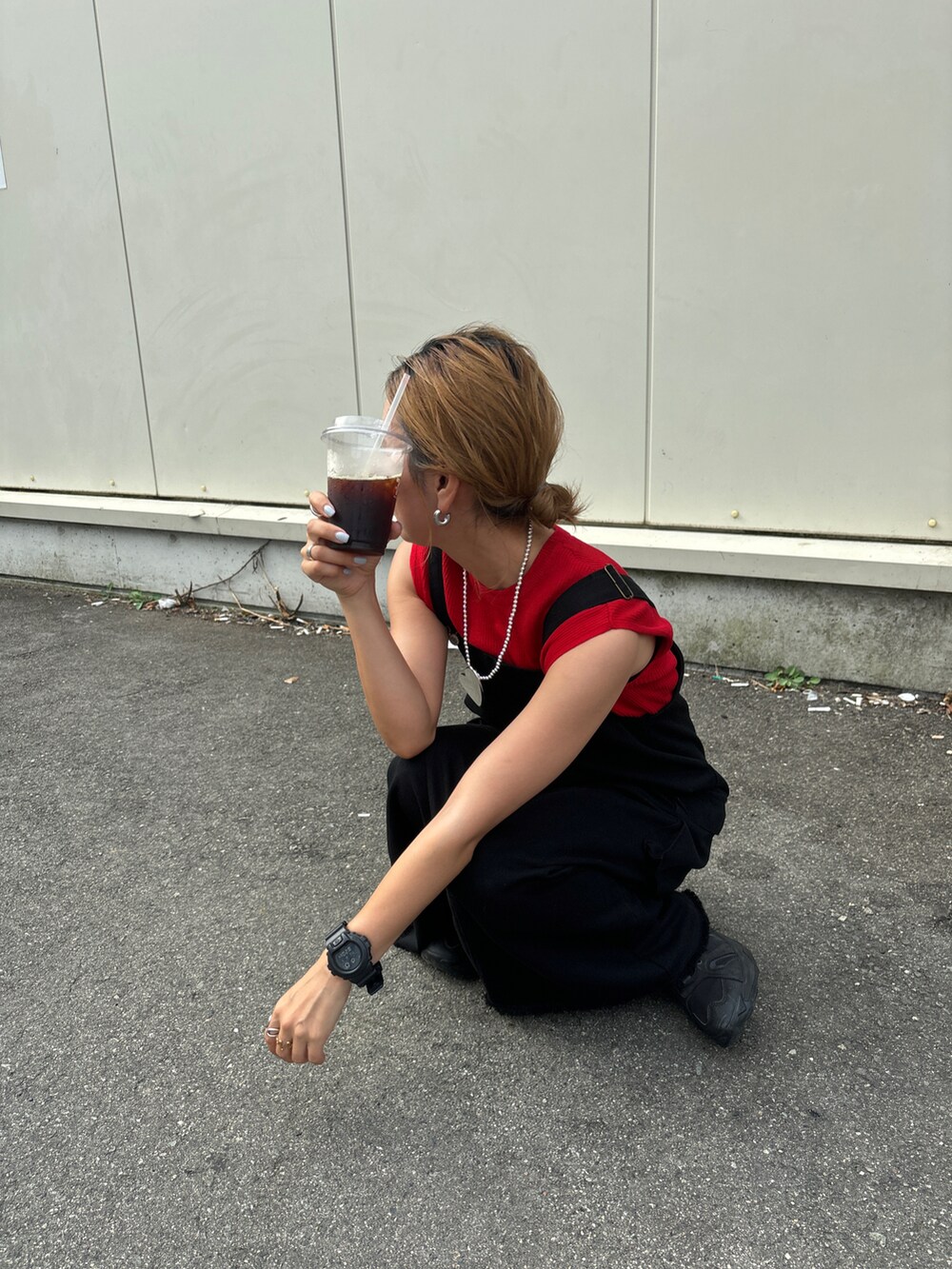 ブラック系のジャンパースカート、レッド系のその他トップス、ブラック系のスニーカーを着用したレディースの夏コーディネートの2枚目の写真