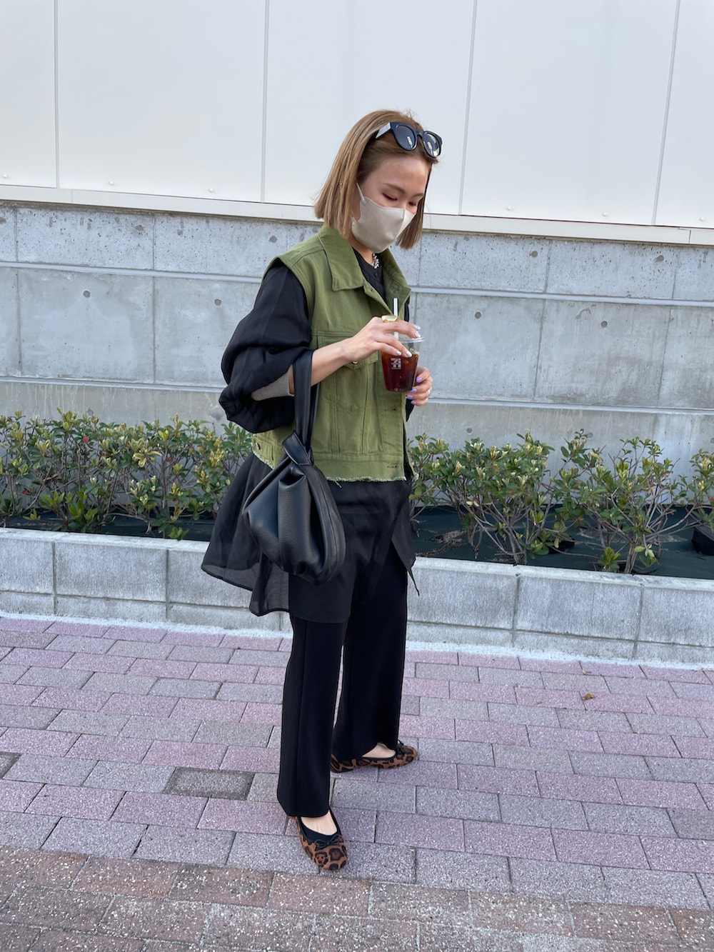 グリーン系のベスト、ブラック系のその他パンツ、ブラック系のシャツ/ブラウスを着用したレディースの春コーディネートの2枚目の写真