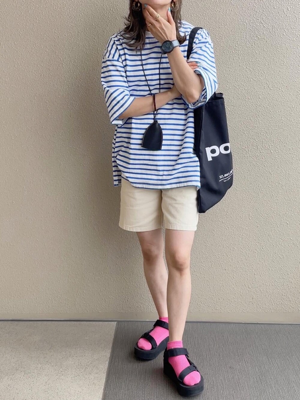 ホワイト系のパンツ、ホワイト系のニット/セーター、ブラウン系のサンダルを着用したレディースの夏コーディネートの2枚目の写真