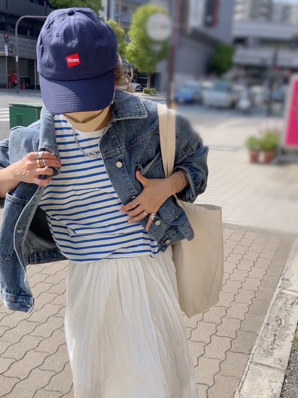 ブルー系のTシャツ/カットソー、ホワイト系のトートバッグ、ホワイト系のスカートを着用したレディースの春コーディネートの3枚目の写真