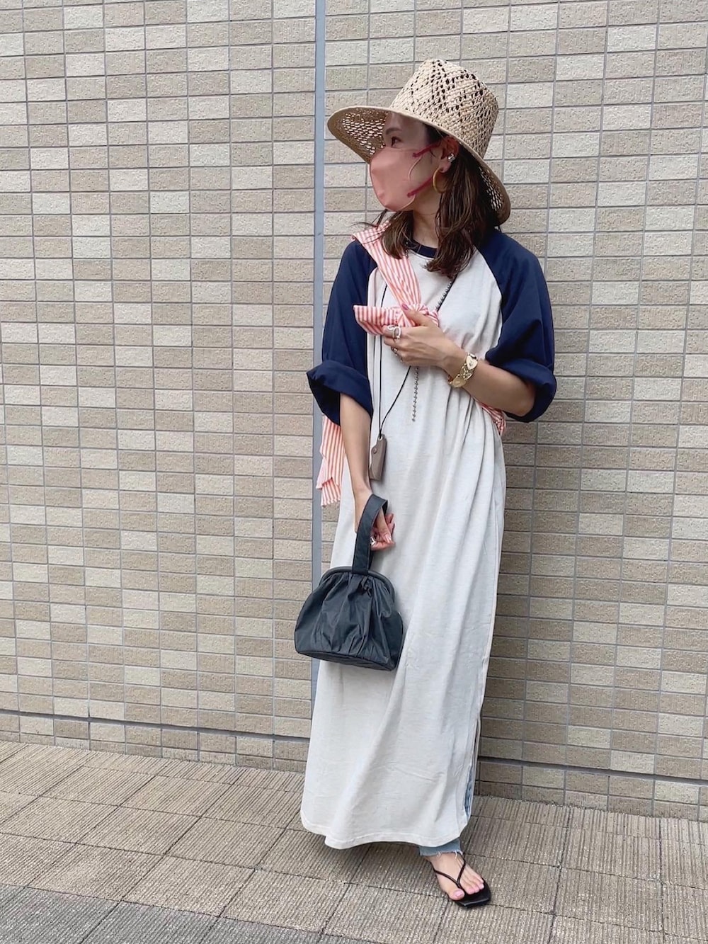 オレンジ系のシャツ/ブラウス、ベージュ系のハットを着用したレディースの夏コーディネートの2枚目の写真