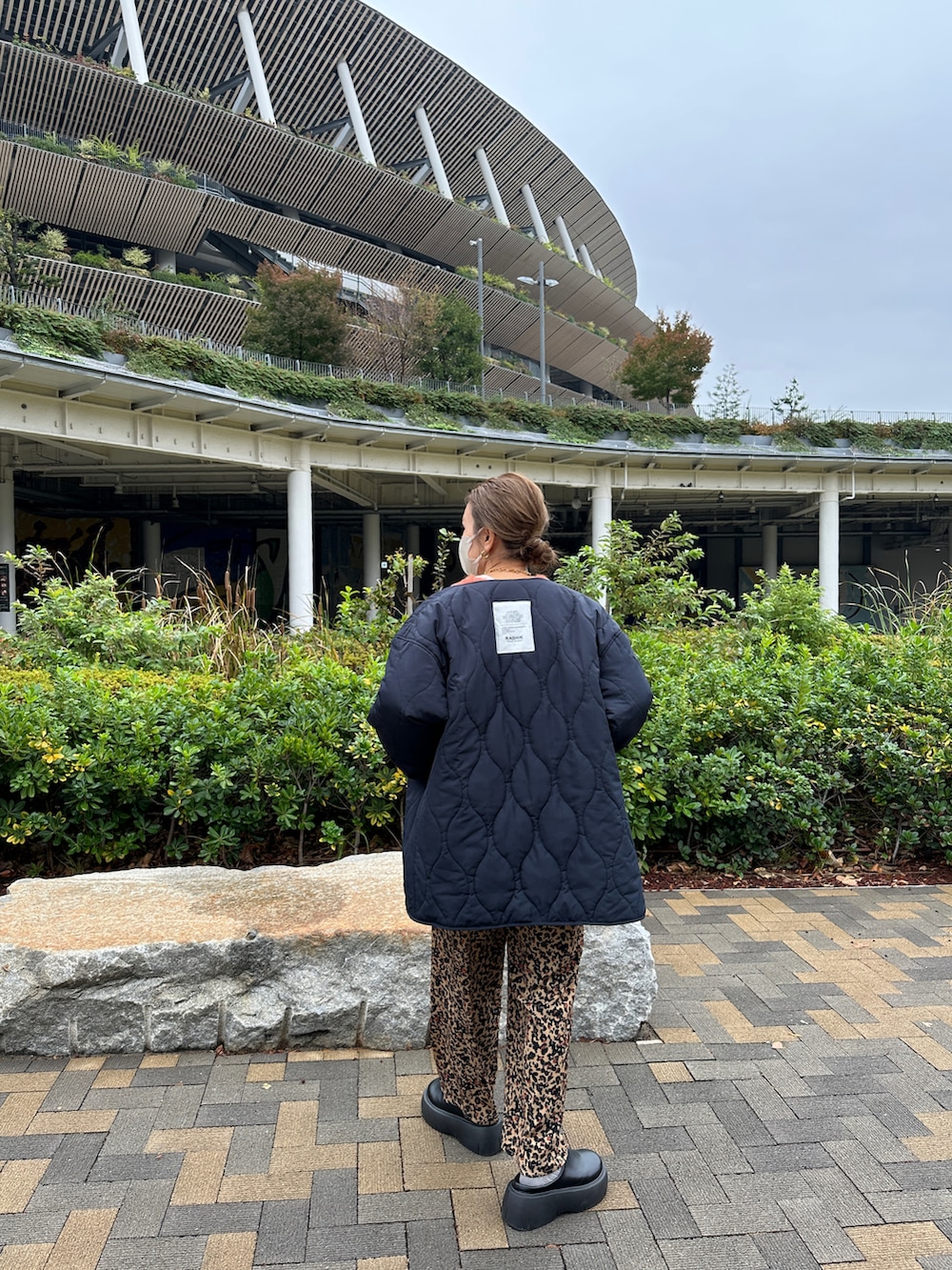 オレンジ系のニット/セーター、ブラウン系のその他パンツ、ブルー系のモッズコートを着用したレディースの冬コーディネートの4枚目の写真