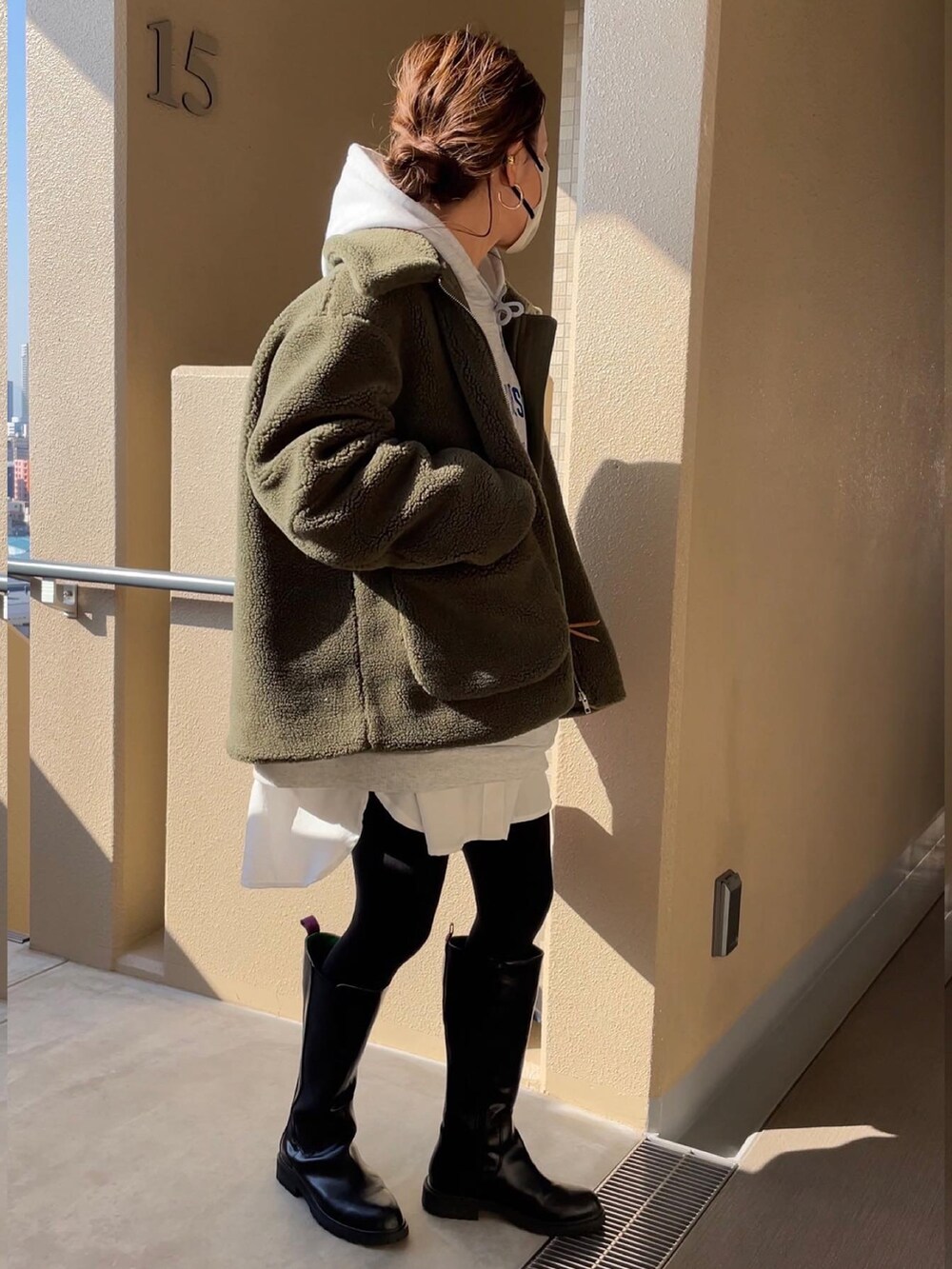 グリーン系のその他アウター、ブラック系のブーツを着用したレディースの秋コーディネートの3枚目の写真