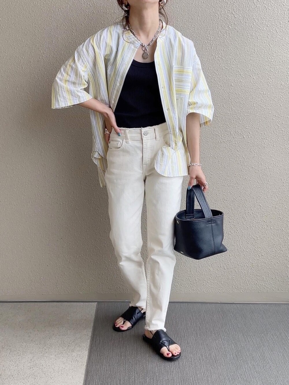 イエロー系のシャツ/ブラウス、ブラウン系のワンピース、ブラウン系のサンダルを着用したレディースの春コーディネートの3枚目の写真