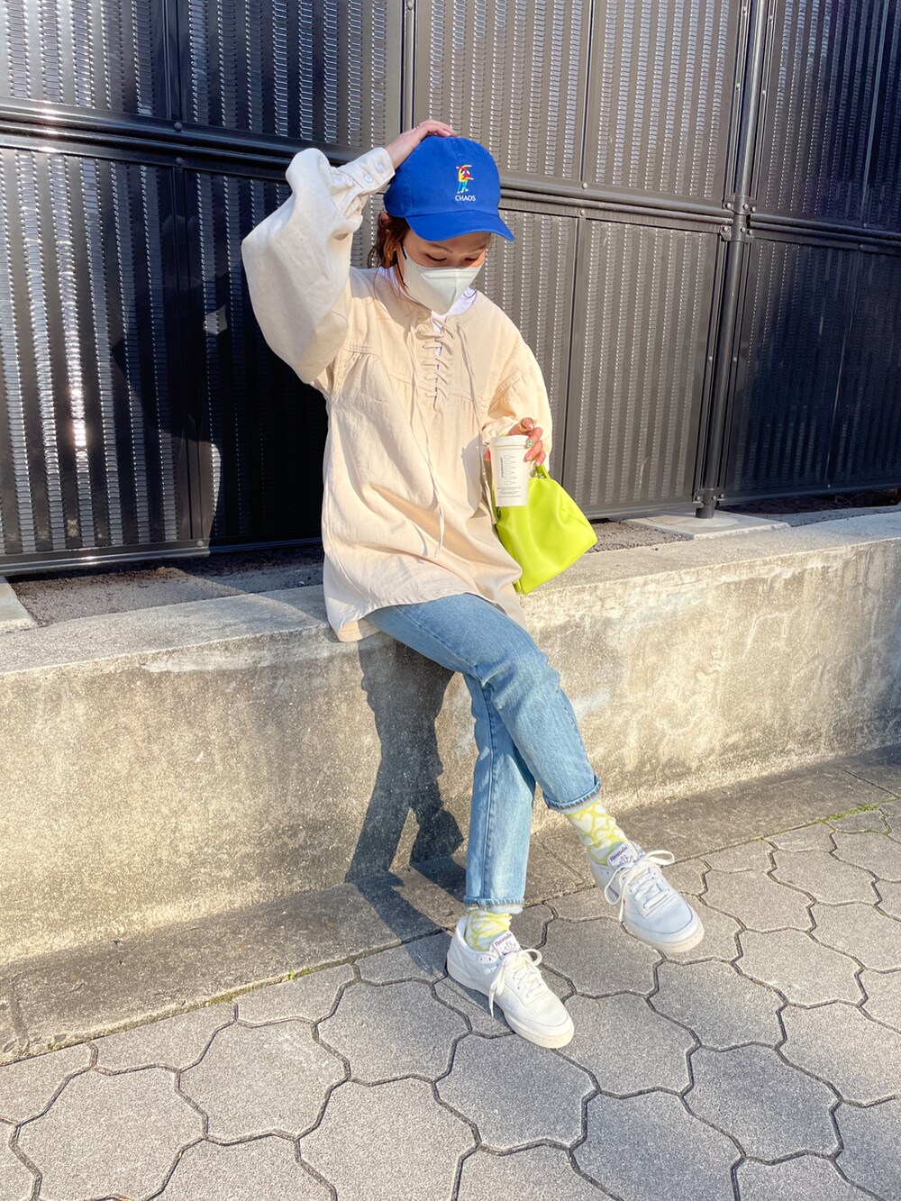 ホワイト系のスニーカー、ブルー系のデニムパンツ、ホワイト系のシャツ/ブラウスを着用したレディースの冬コーディネートの4枚目の写真