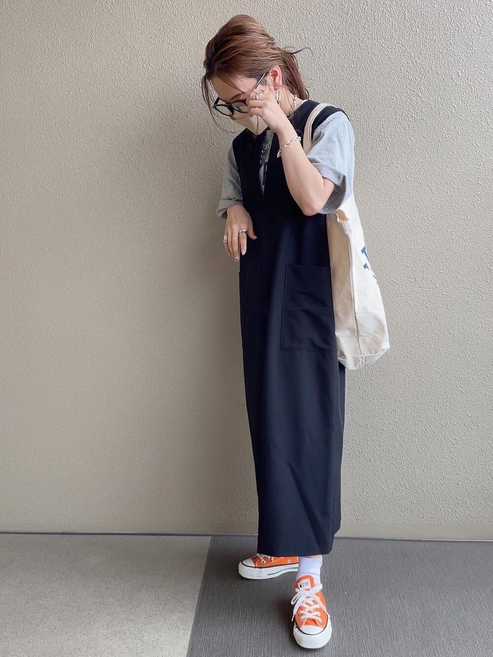ブラック系のジャンパースカート、ピンク系のシャツ/ブラウス、グレー系のTシャツ/カットソーを着用したレディースの春コーディネートの5枚目の写真
