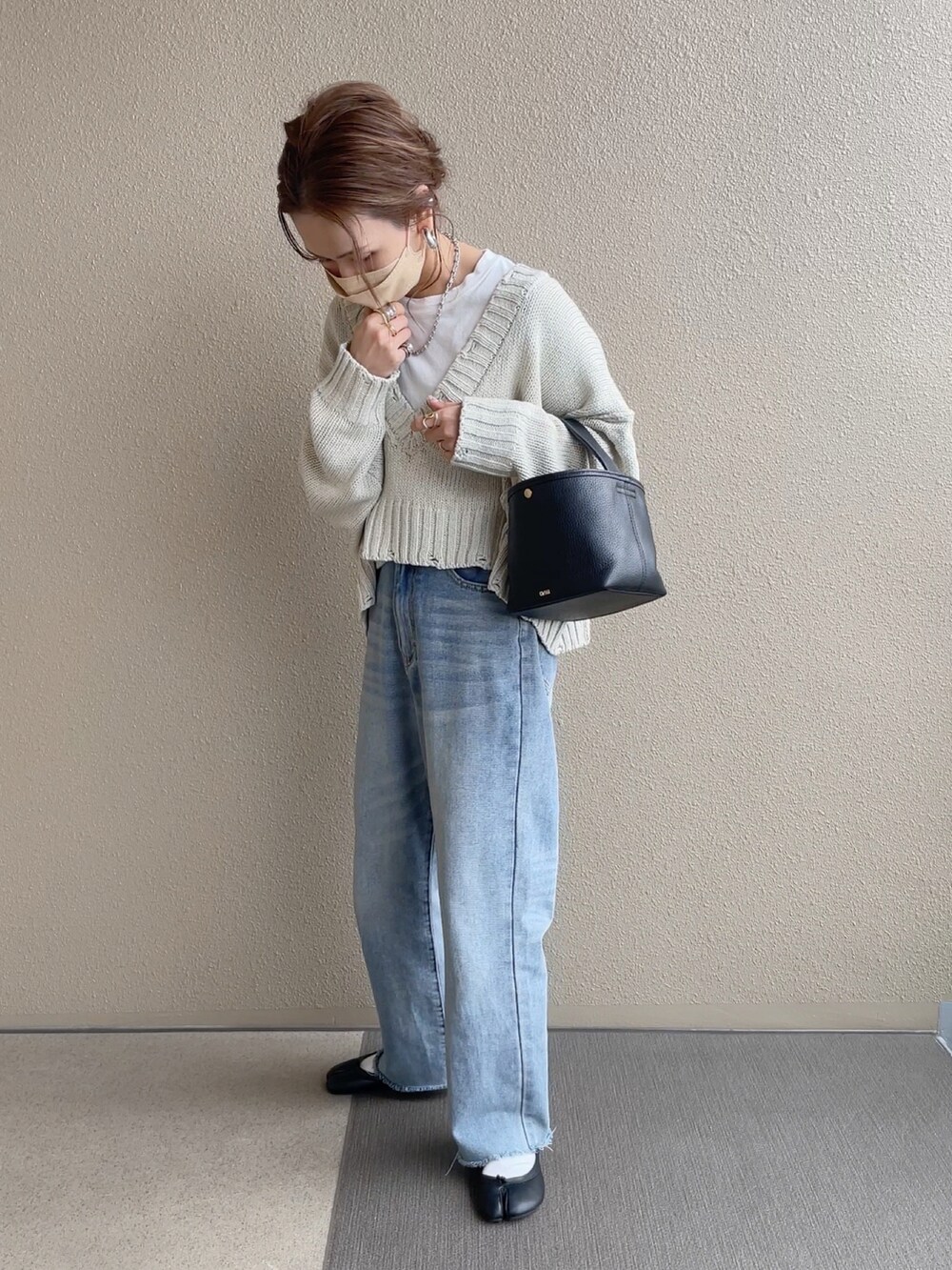 ホワイト系のニット/セーター、ブルー系のデニムパンツ、ブラウン系のシャツワンピースを着用したレディースの冬コーディネートの2枚目の写真