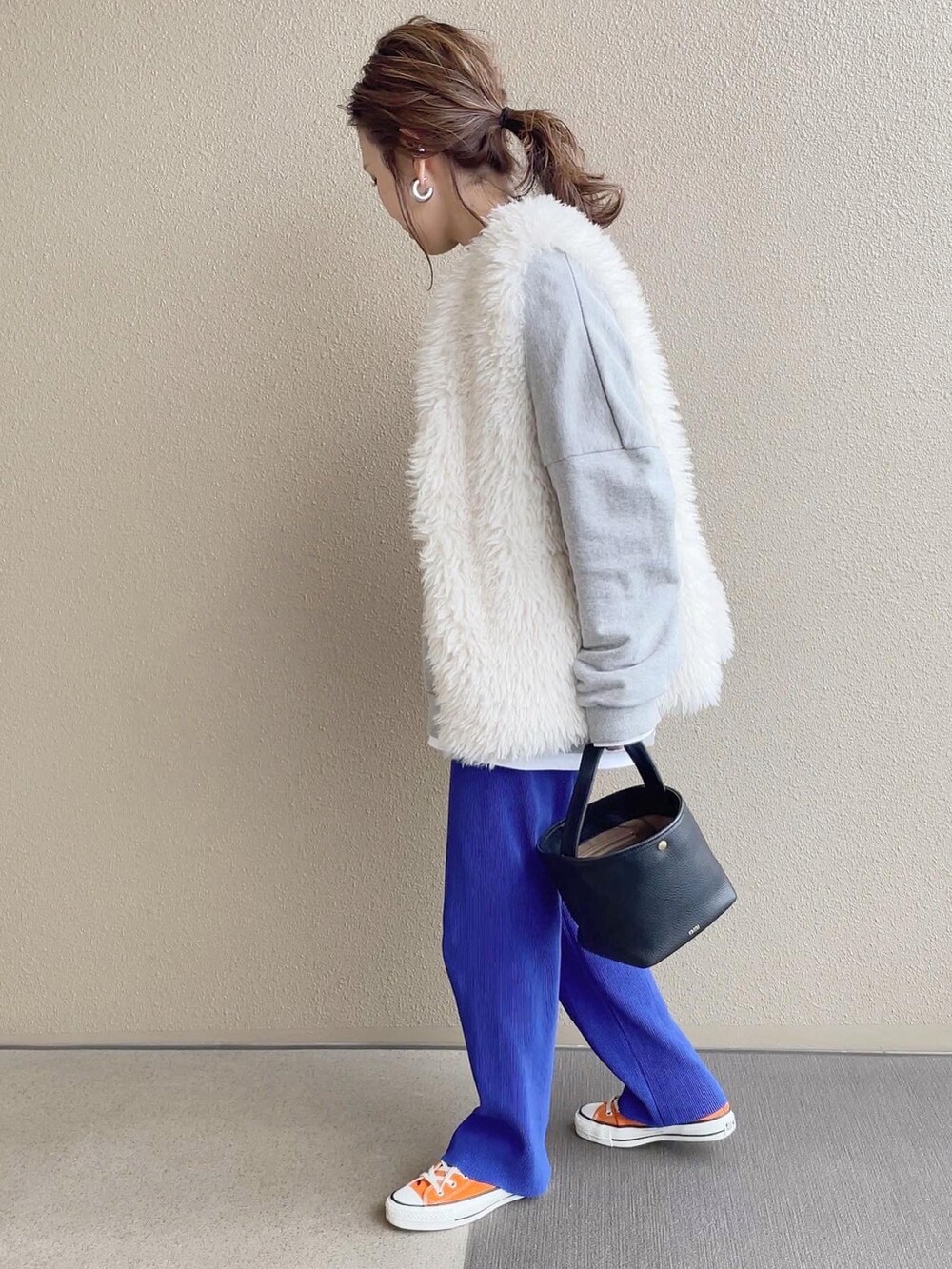 ブルー系のその他パンツ、グレー系のスウェット、オレンジ系のスニーカーを着用したレディースの冬コーディネートの2枚目の写真