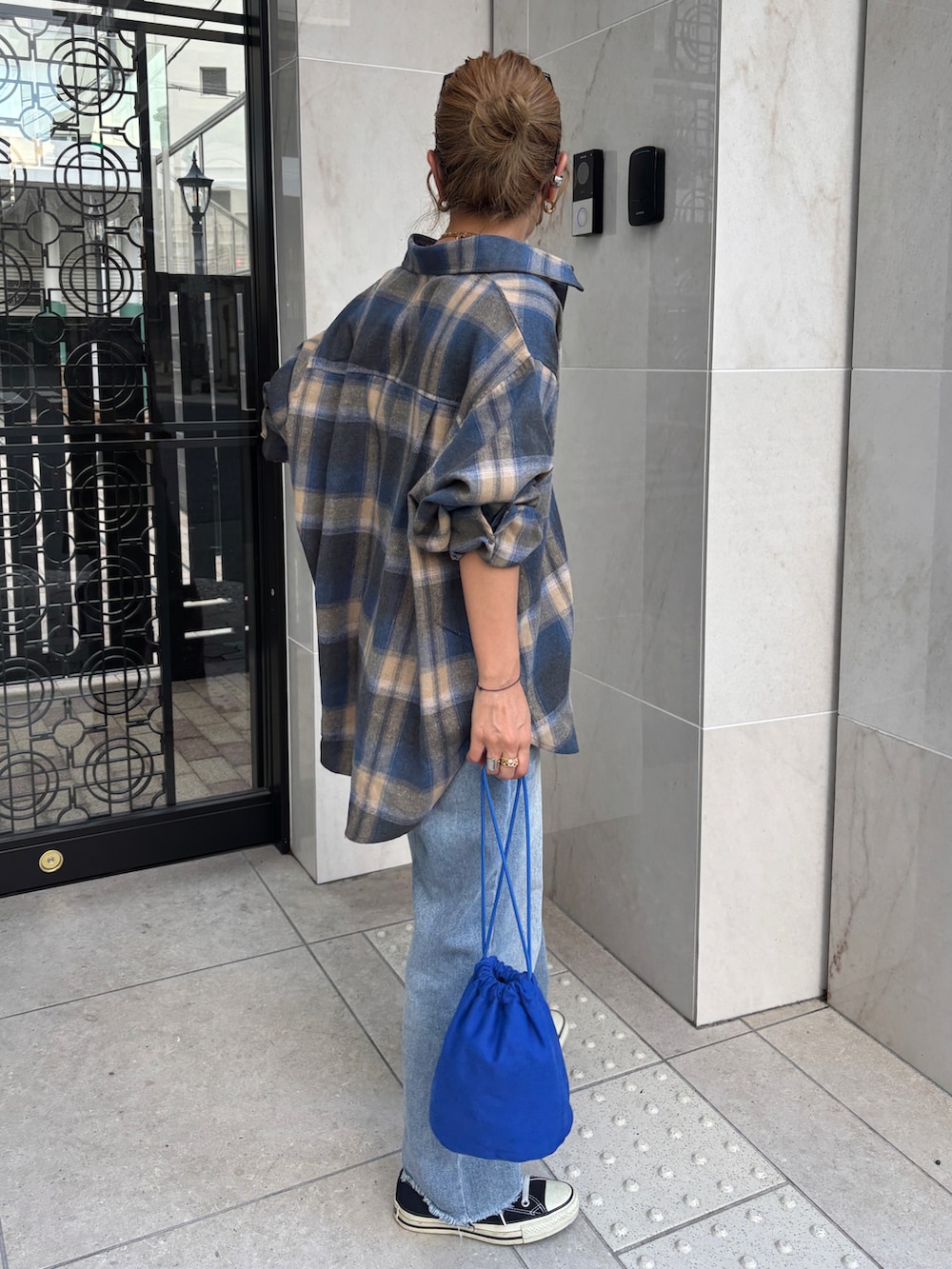 ベージュ系のシャツ/ブラウス、ブルー系のデニムパンツ、ブルー系のショルダーバッグを着用したレディースの秋コーディネートの2枚目の写真