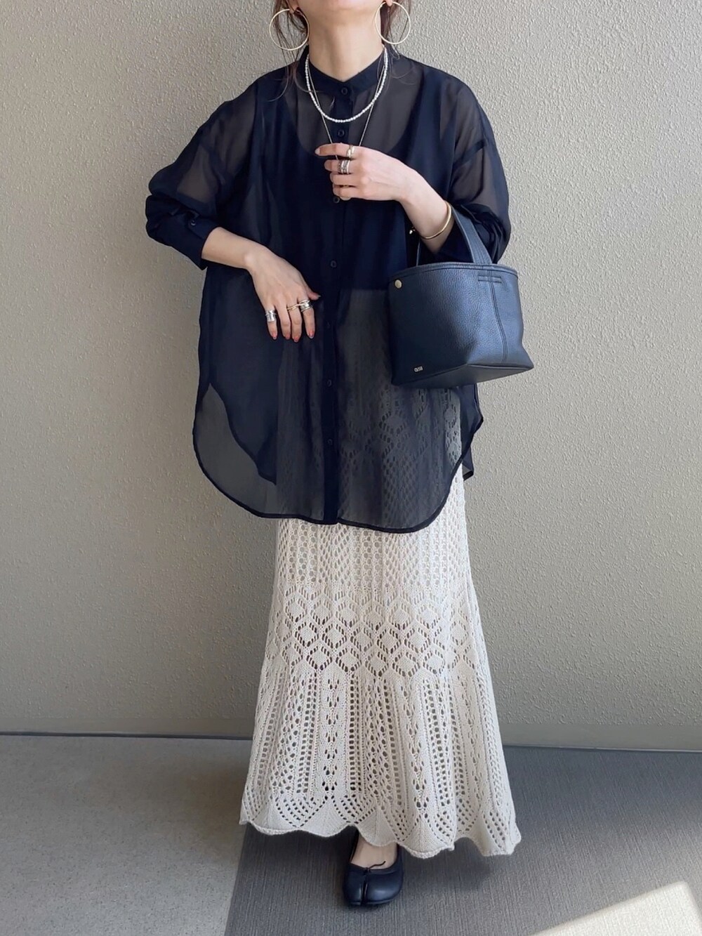 ホワイト系のスカート、ブラック系のTシャツ/カットソー、ブラウン系のベストを着用したレディースの春コーディネートの3枚目の写真