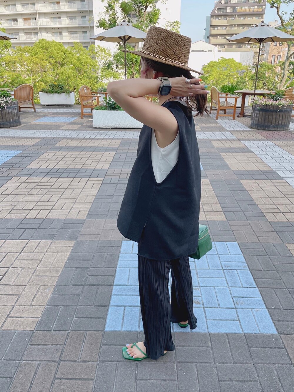 ブラック系のベスト、ブラック系のその他パンツ、グリーン系のサンダルを着用したレディースの夏コーディネートの3枚目の写真