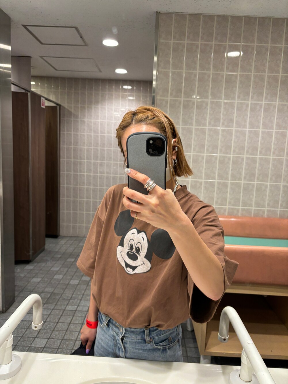 ブルー系のデニムパンツ、ブラック系のスニーカー、ブラウン系のTシャツ/カットソーを着用したレディースの春コーディネートの4枚目の写真