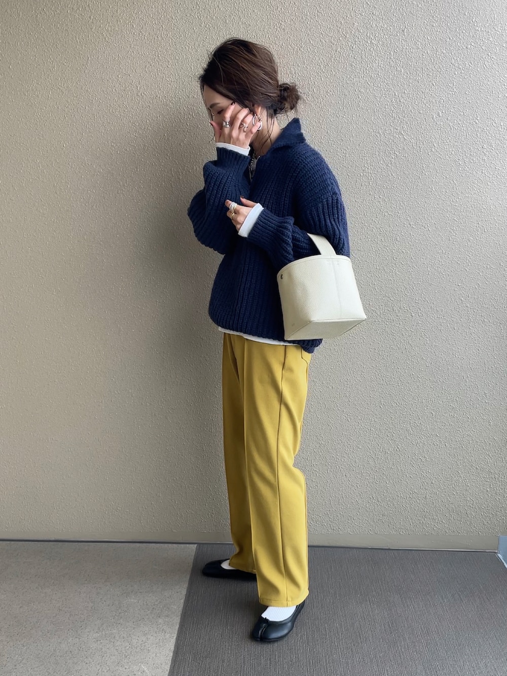 ホワイト系のノーカラージャケット、ブルー系のニット/セーター、イエロー系のその他パンツを着用したレディースの冬コーディネートの5枚目の写真