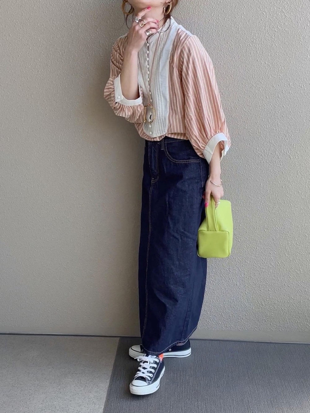 ブルー系のデニムスカート、ブラック系のジャンパースカート、その他のその他を着用したレディースの春コーディネートの2枚目の写真