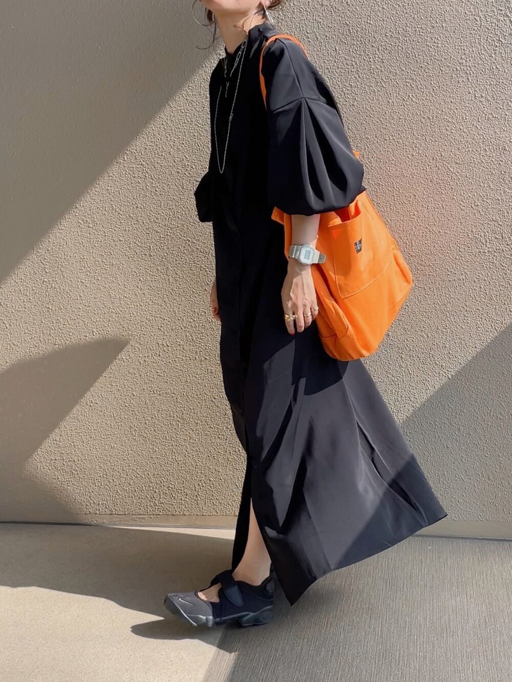 ブラック系のワンピース、ブラック系のサンダル、グリーン系のベストを着用したレディースの夏コーディネートの2枚目の写真