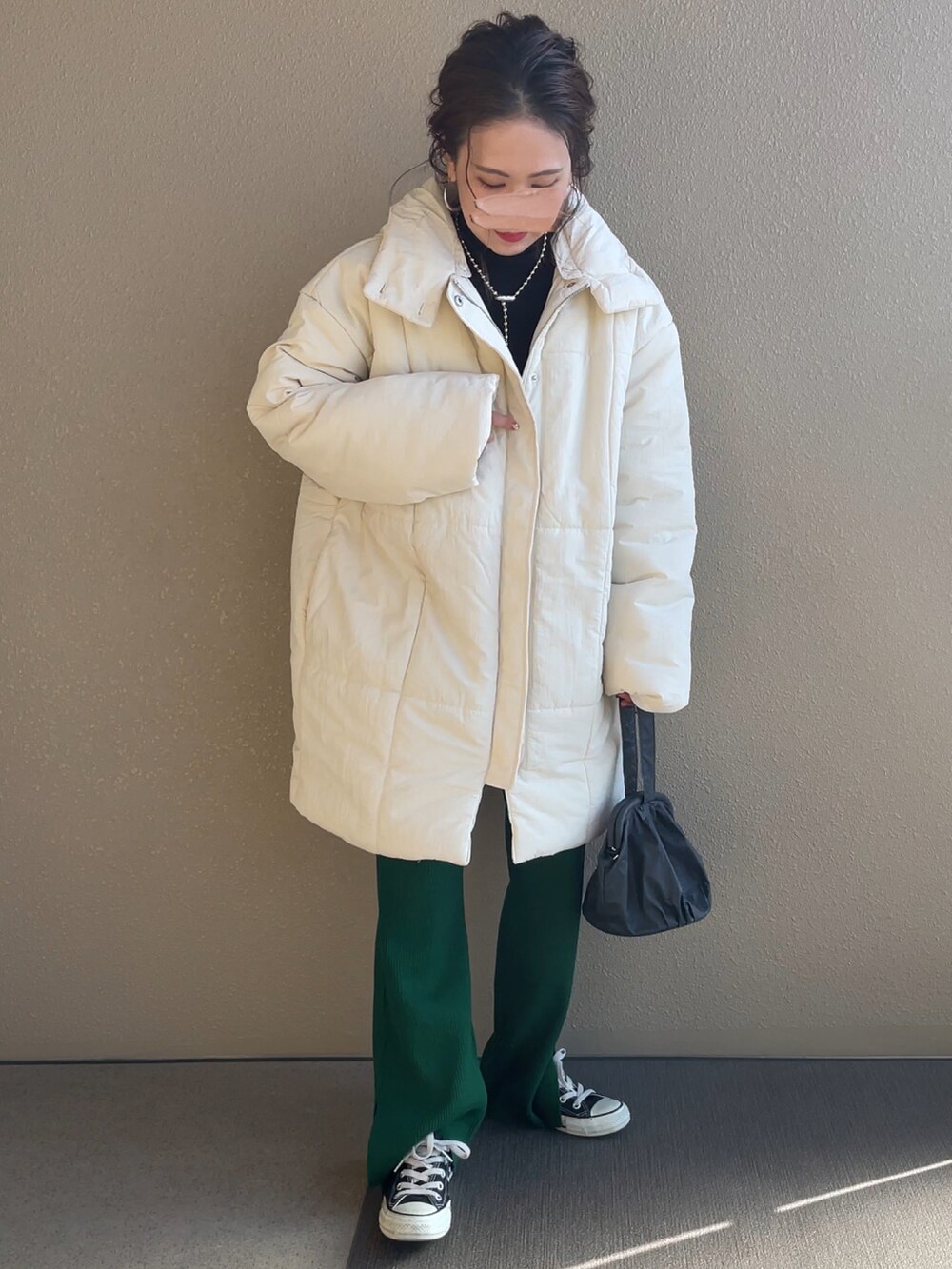 ホワイト系のダウンジャケット/コート、ブラック系のニット/セーター、グリーン系のパンツを着用したレディースの秋コーディネートの2枚目の写真