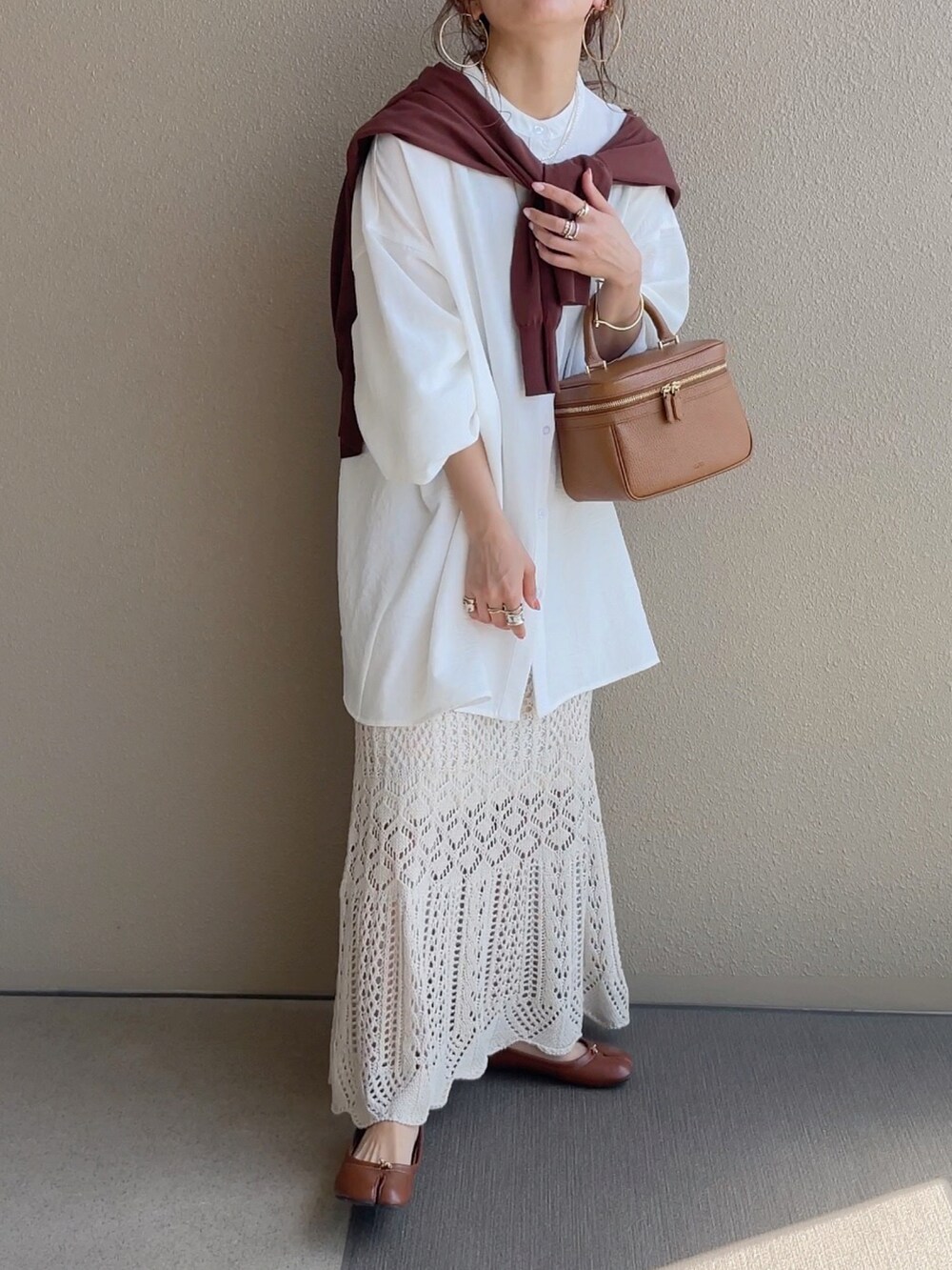 ホワイト系のスカート、ブラック系のTシャツ/カットソー、ブラウン系のベストを着用したレディースの春コーディネートの4枚目の写真