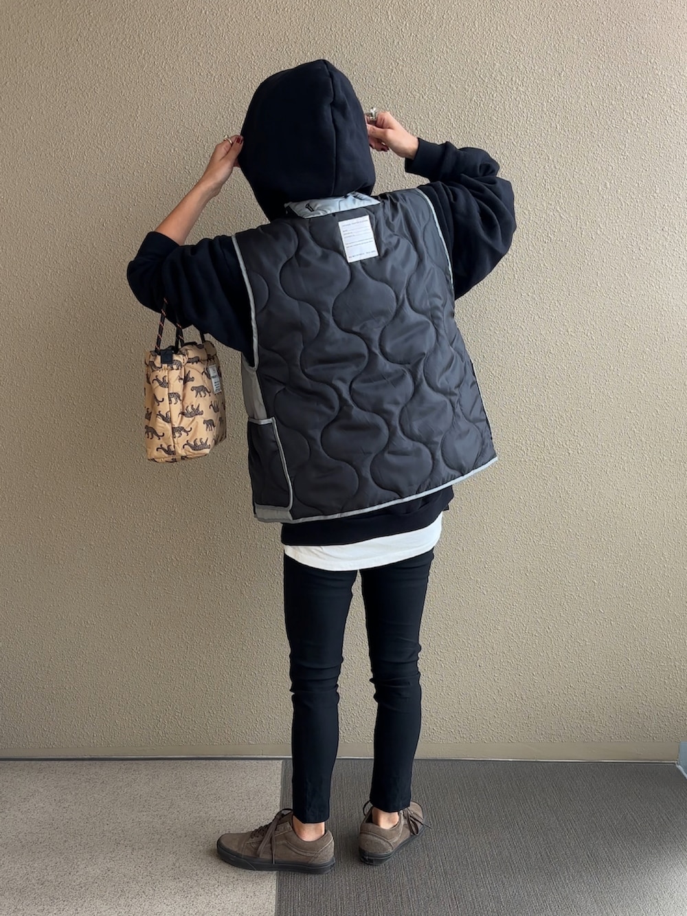 ブラック系のその他アウター、ブラック系のパーカー、ベージュ系のショルダーバッグを着用したレディースの秋コーディネートの3枚目の写真