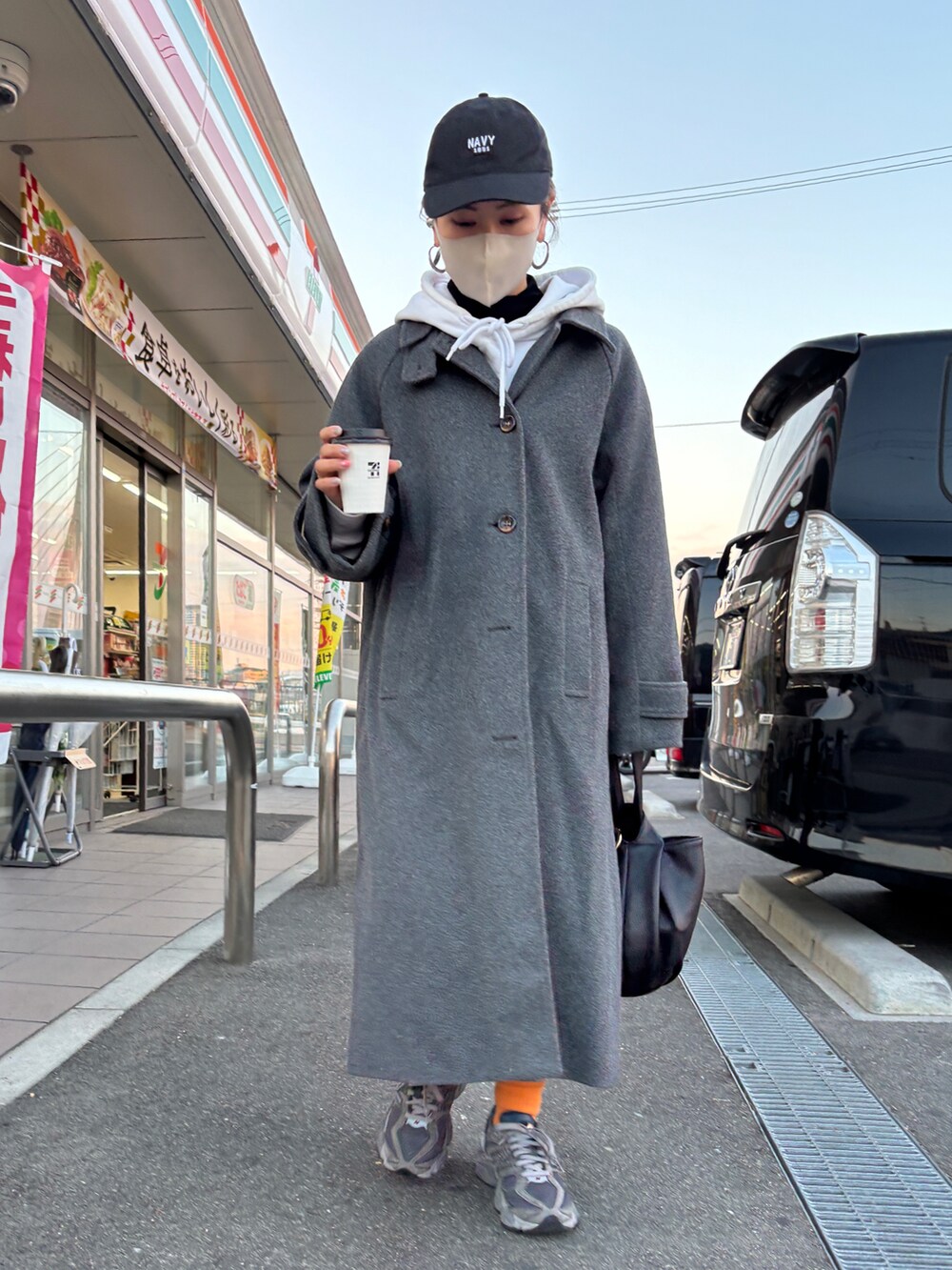 グレー系のステンカラーコートを着用したレディースの冬コーディネートの2枚目の写真