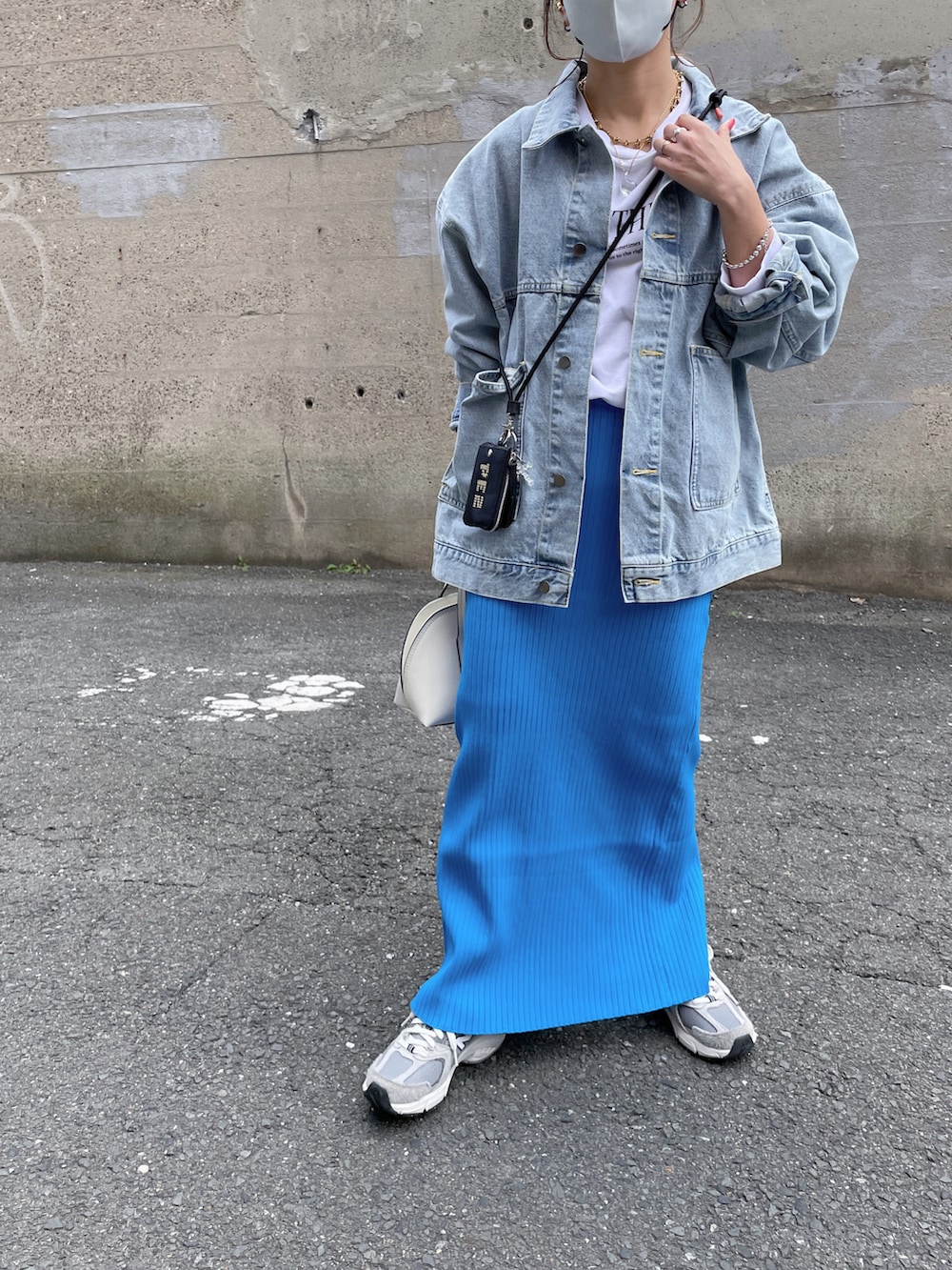 ブルー系のデニムジャケット、ホワイト系のスウェット、ブラック系のカードケースを着用したレディースの春コーディネートの3枚目の写真