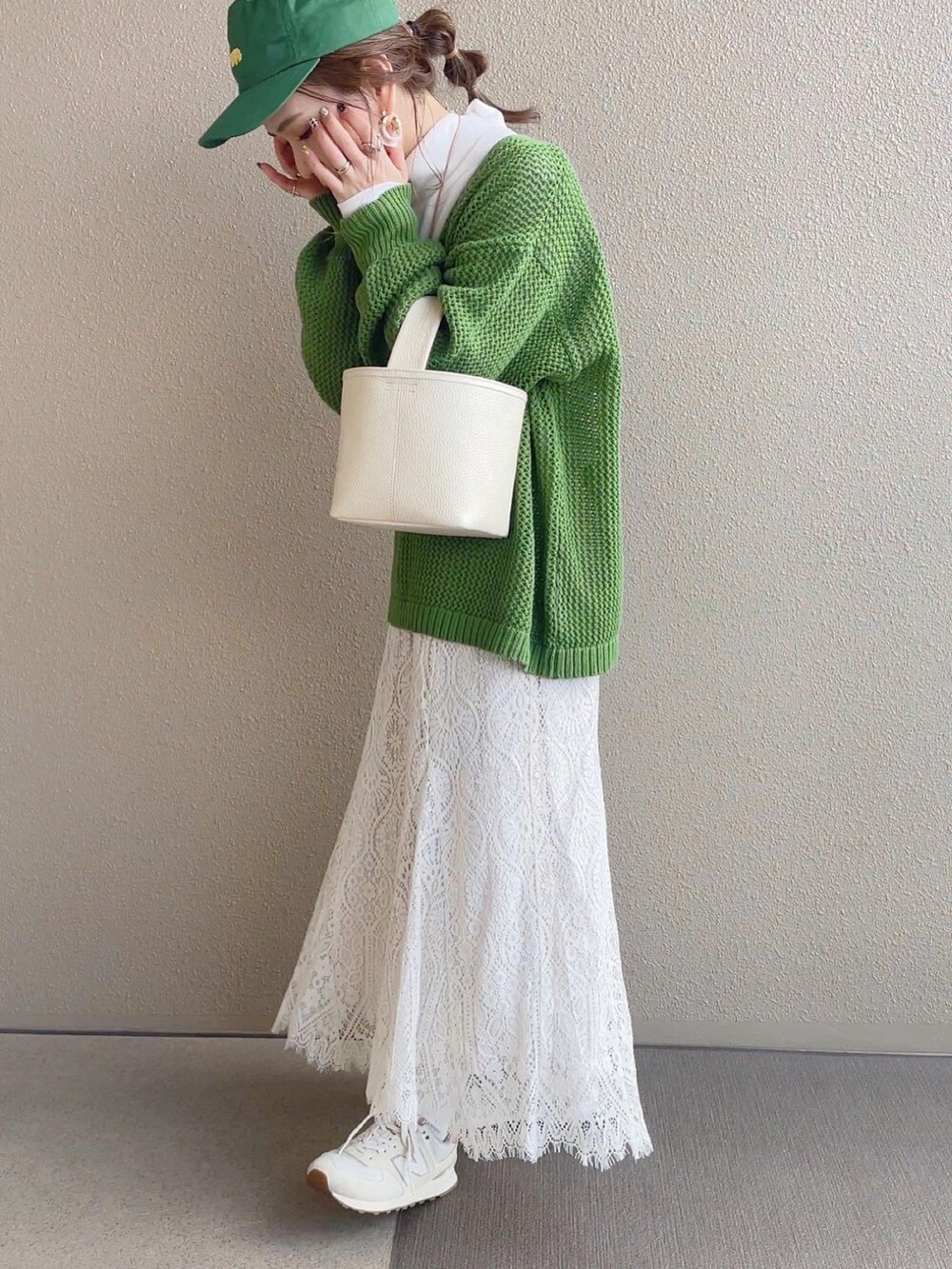 グリーン系のニット/セーター、ホワイト系のスカート、ベージュ系のスニーカーを着用したレディースの冬コーディネートの4枚目の写真