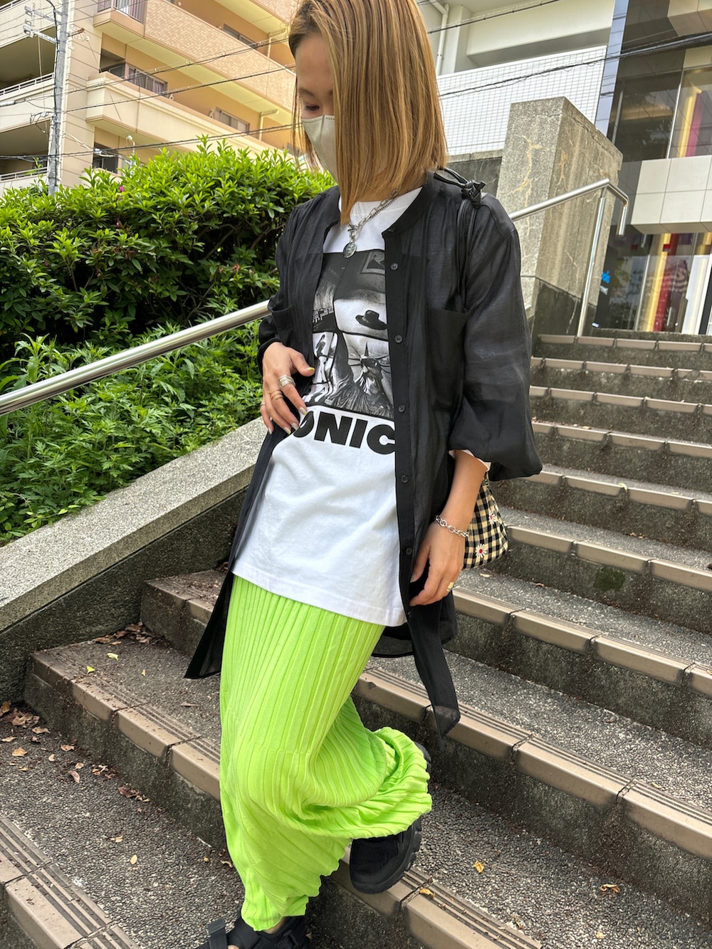 ブラック系のシャツ/ブラウス、ホワイト系のTシャツ/カットソー、グリーン系のスカートを着用したレディースの春コーディネートの3枚目の写真