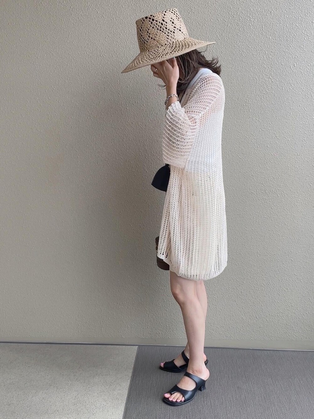 ホワイト系のパンツ、ホワイト系のニット/セーター、ブラウン系のサンダルを着用したレディースの夏コーディネートの4枚目の写真