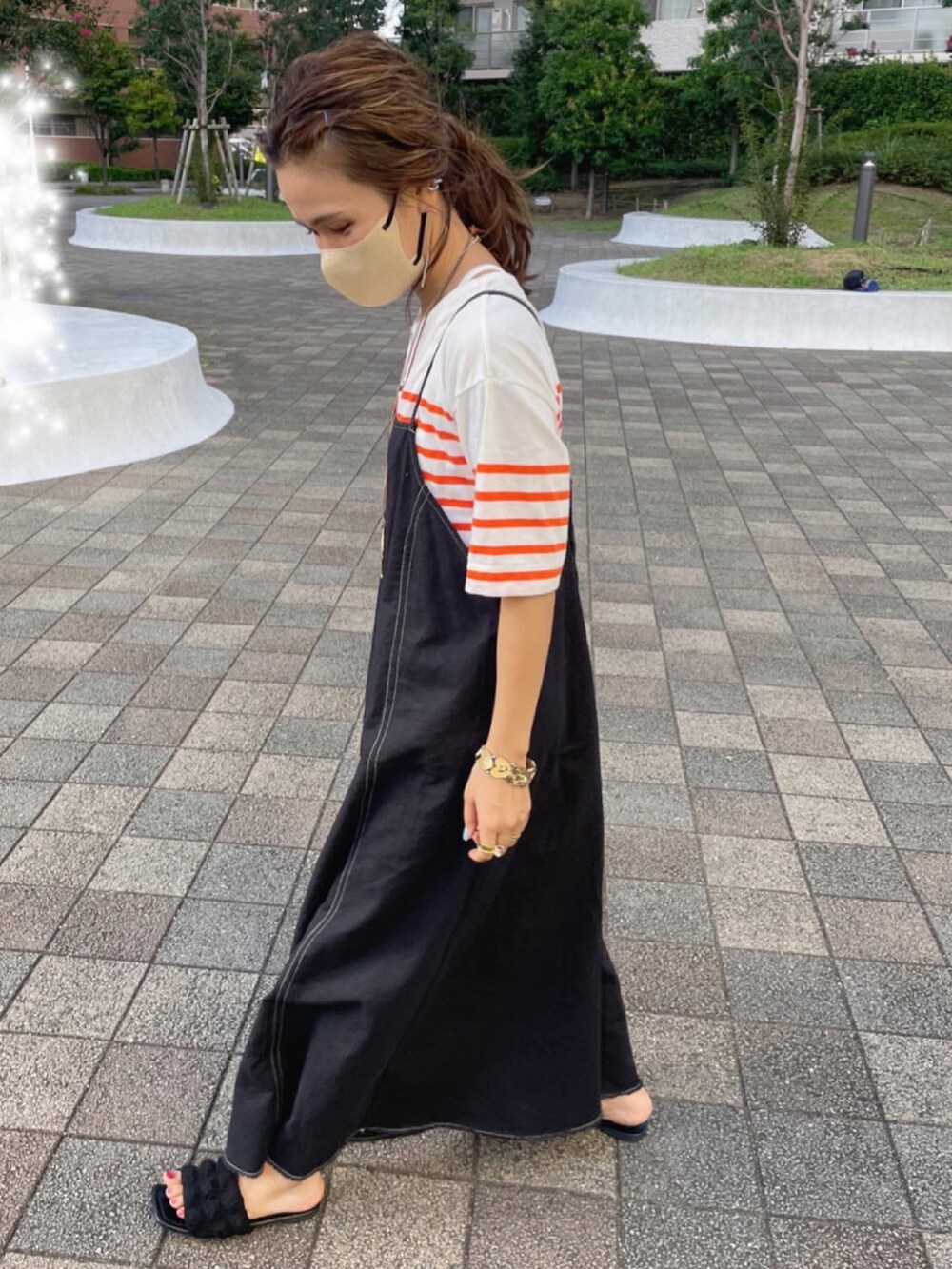 オレンジ系のTシャツ/カットソー、ブラック系のワンピースを着用したレディースの秋コーディネートの2枚目の写真