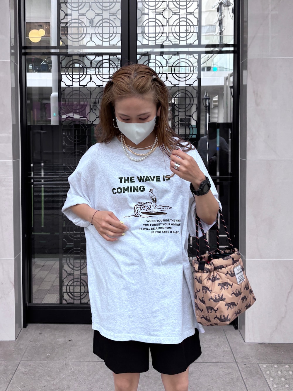 グレー系のTシャツ/カットソー、ベージュ系のショルダーバッグ、ブラック系のスニーカーを着用したレディースの夏コーディネートの3枚目の写真