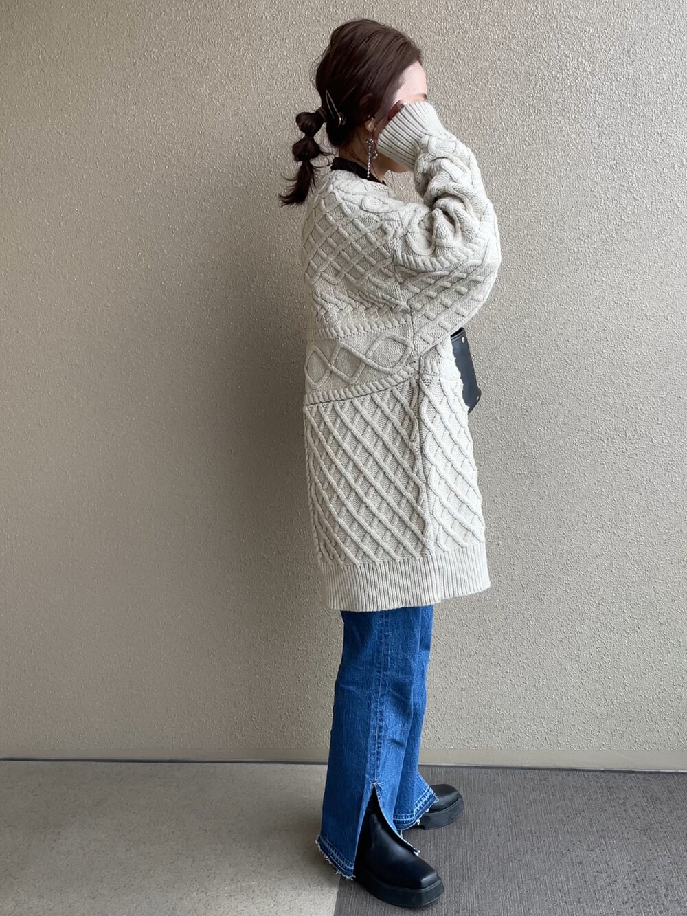 ブルー系のデニムパンツ、ホワイト系のニット/セーター、ブラック系のブーツを着用したレディースの冬コーディネートの4枚目の写真