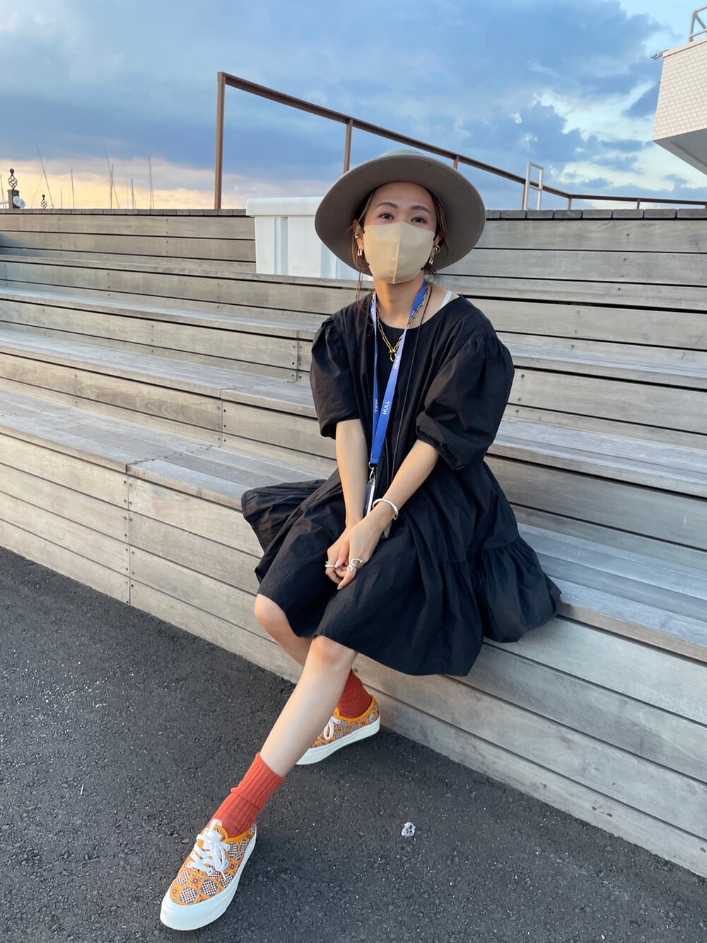 ブラック系のワンピース、イエロー系のスニーカー、ベージュ系のハットを着用したレディースの秋コーディネートの2枚目の写真