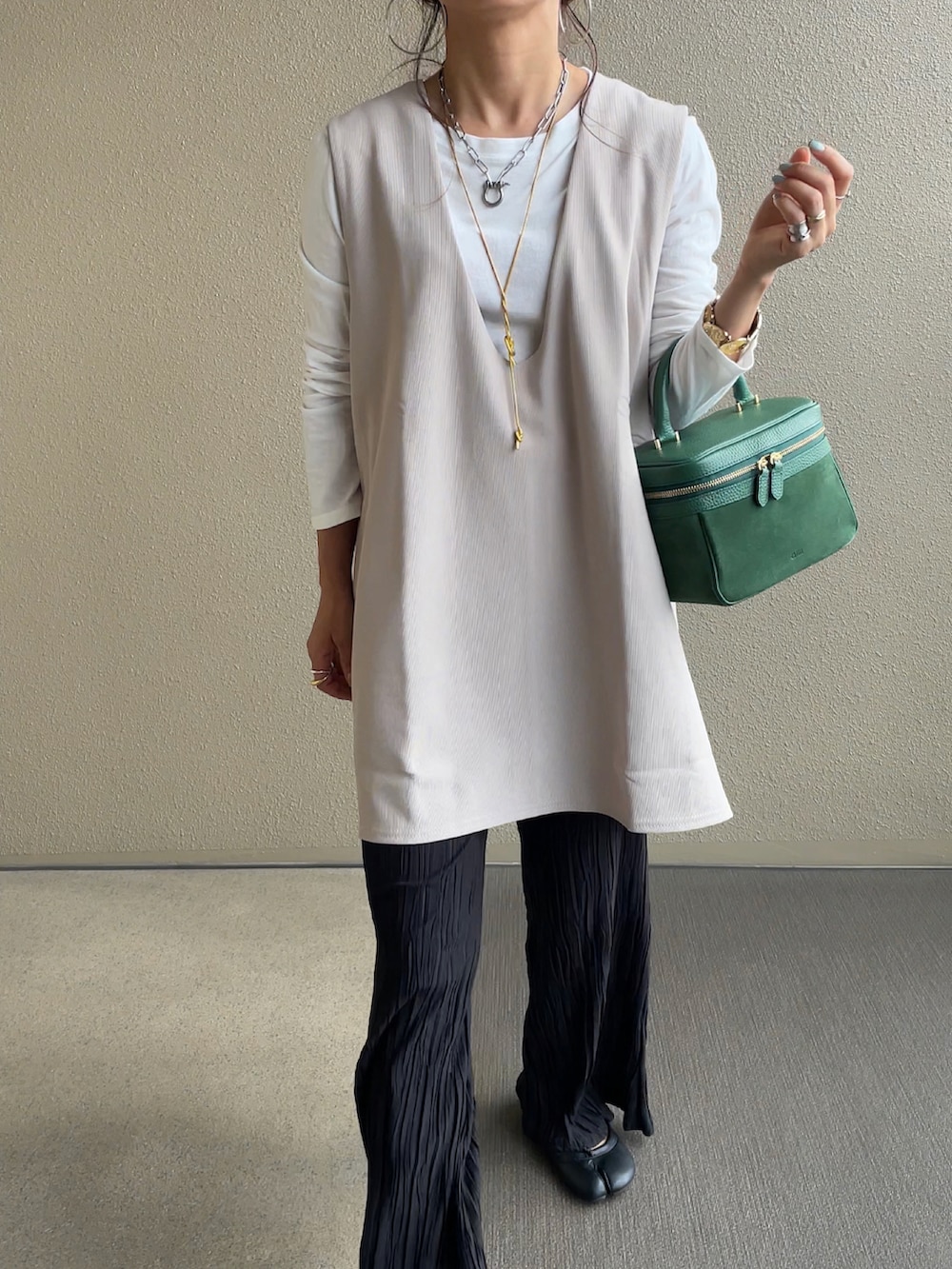 ベージュ系のベスト、ブラック系のその他パンツを着用したレディースの秋コーディネートの2枚目の写真