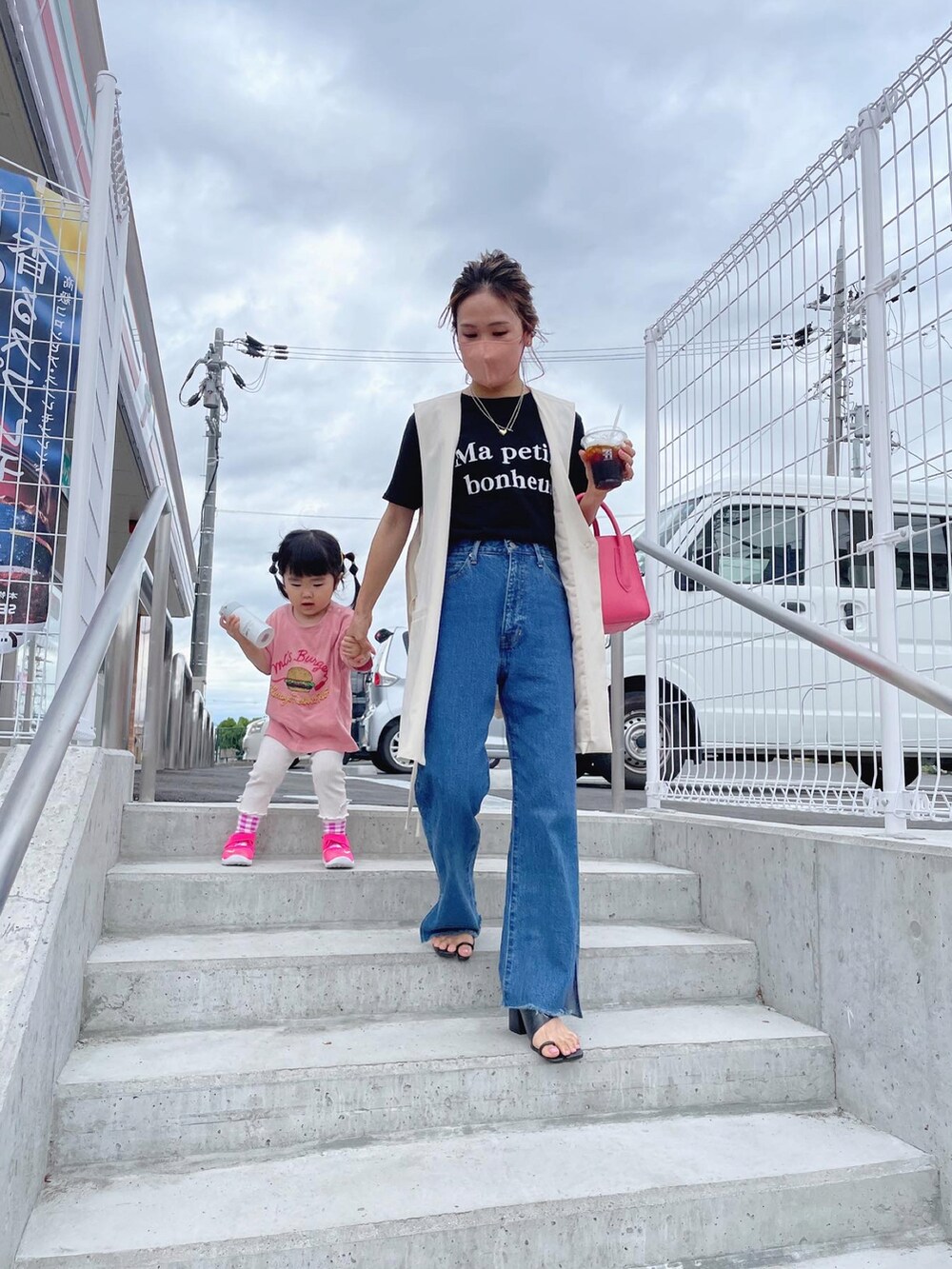 ブルー系のデニムパンツ、ブラック系のサンダル、ピンク系のTシャツ/カットソーを着用したレディースの夏コーディネートの2枚目の写真