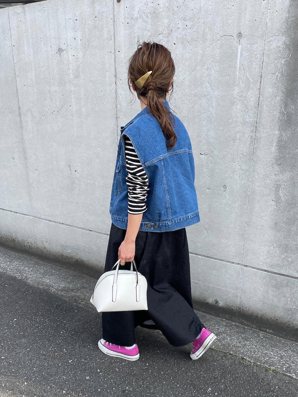 ブルー系のベスト、ブラック系のワンピース、ピンク系のスニーカーを着用したレディースの春コーディネートの3枚目の写真