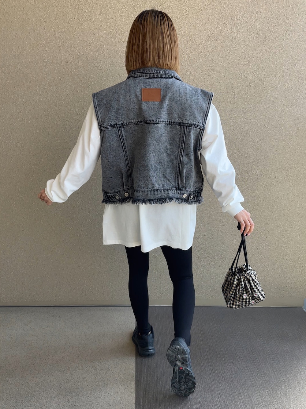 ホワイト系のTシャツ/カットソー、ブラック系のスニーカー、その他のハンドバッグを着用したレディースの春コーディネートの5枚目の写真