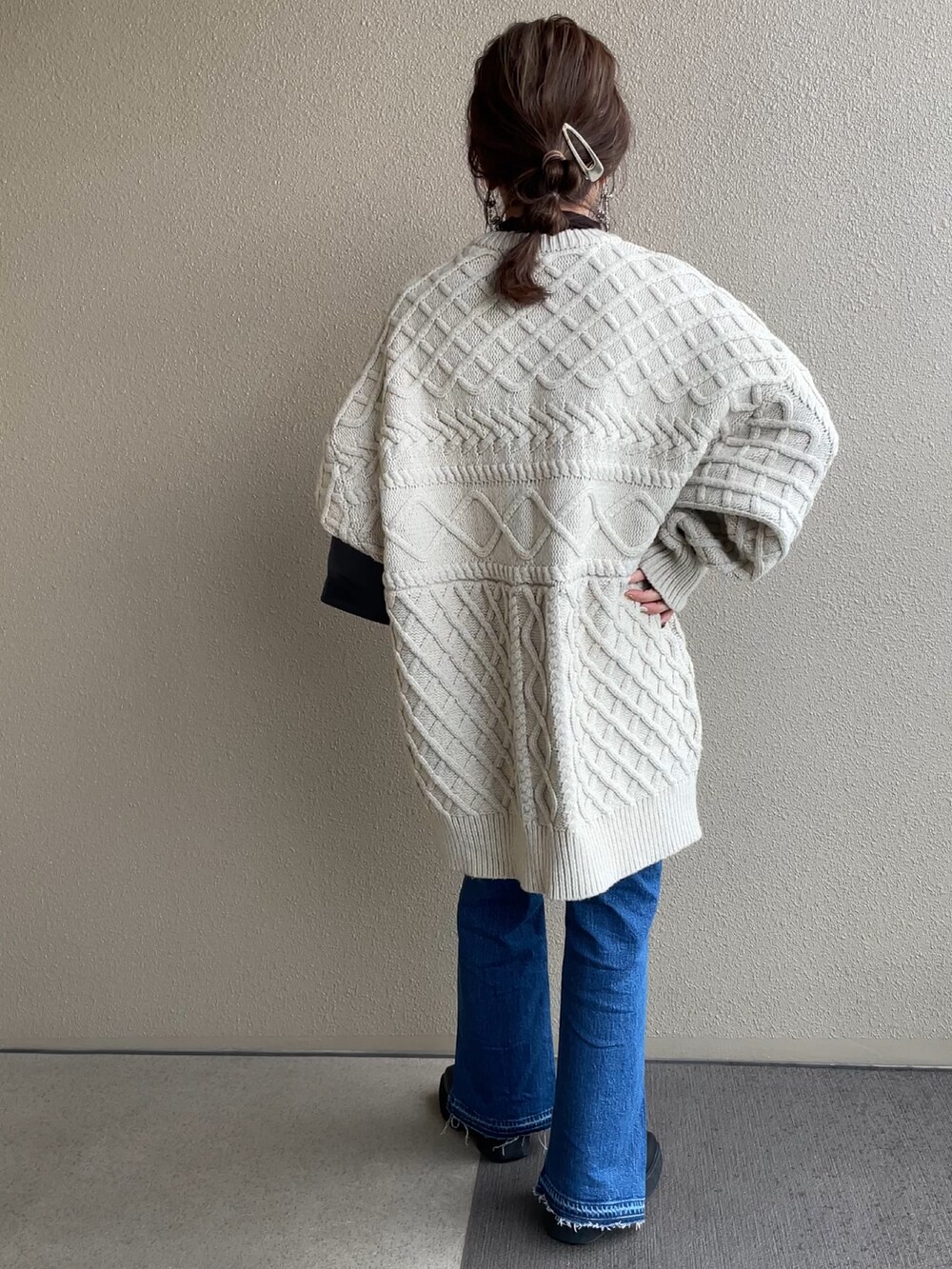 ブルー系のデニムパンツ、ホワイト系のニット/セーター、ブラック系のブーツを着用したレディースの冬コーディネートの2枚目の写真