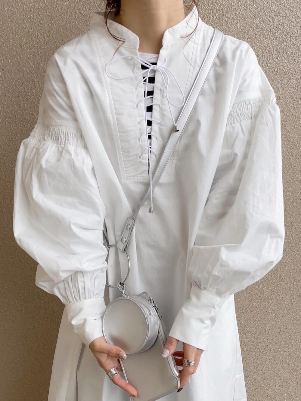 ホワイト系のワンピース、ブルー系のその他パンツ、ホワイト系のショルダーバッグを着用したレディースの冬コーディネートの3枚目の写真