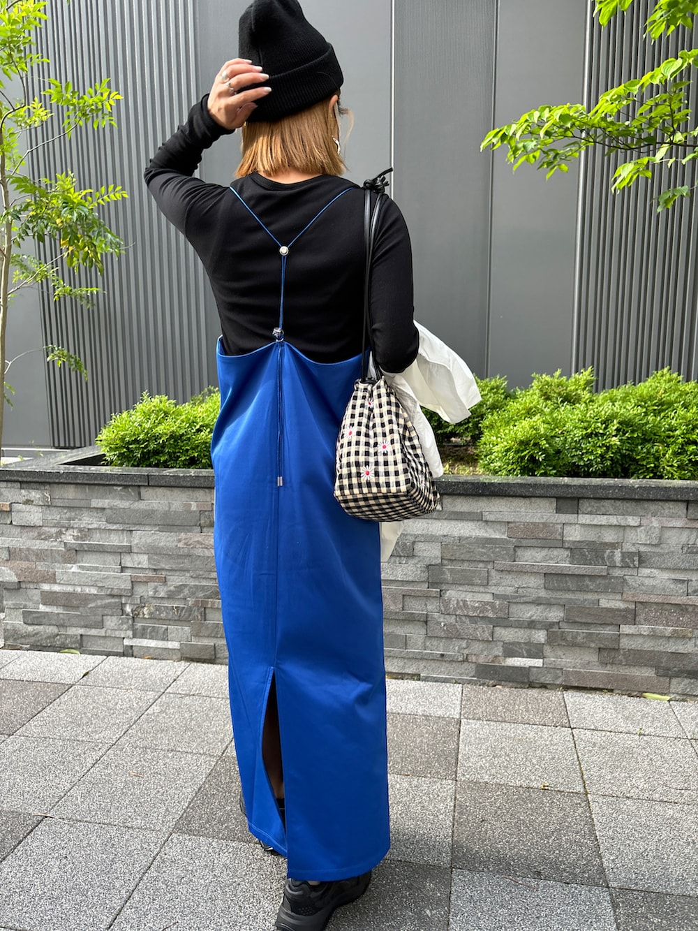 ブルー系のワンピース、ホワイト系のナイロンジャケットを着用したレディースの春コーディネートの2枚目の写真