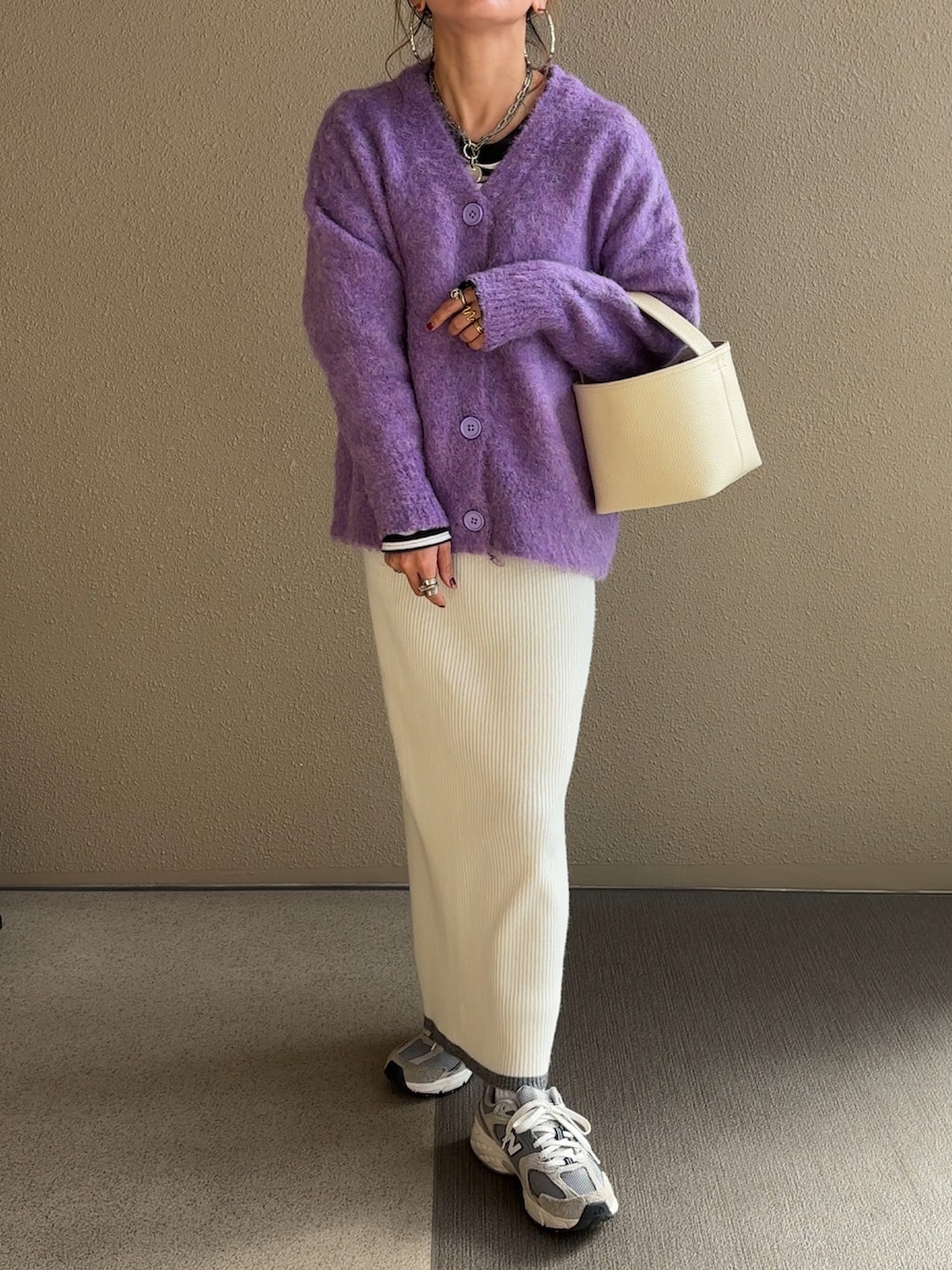 パープル系のカーディガン/ボレロ、ブラック系のTシャツ/カットソー、ブラック系のジャンパースカートを着用したレディースの秋コーディネートの3枚目の写真