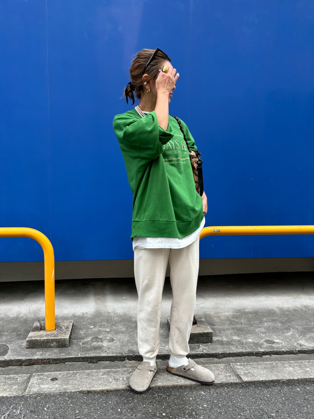 グリーン系のスウェット、ホワイト系のスウェットパンツを着用したレディースの秋コーディネートの3枚目の写真